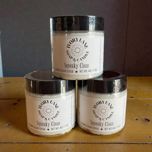 Three jars of Ivory Lane Soap & Candle Squeaky Clean scrub stacked on a wooden surface.